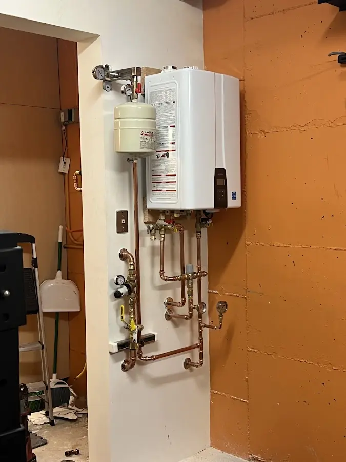 Plumbing technician inspecting water heater connections in Benton Harbor
